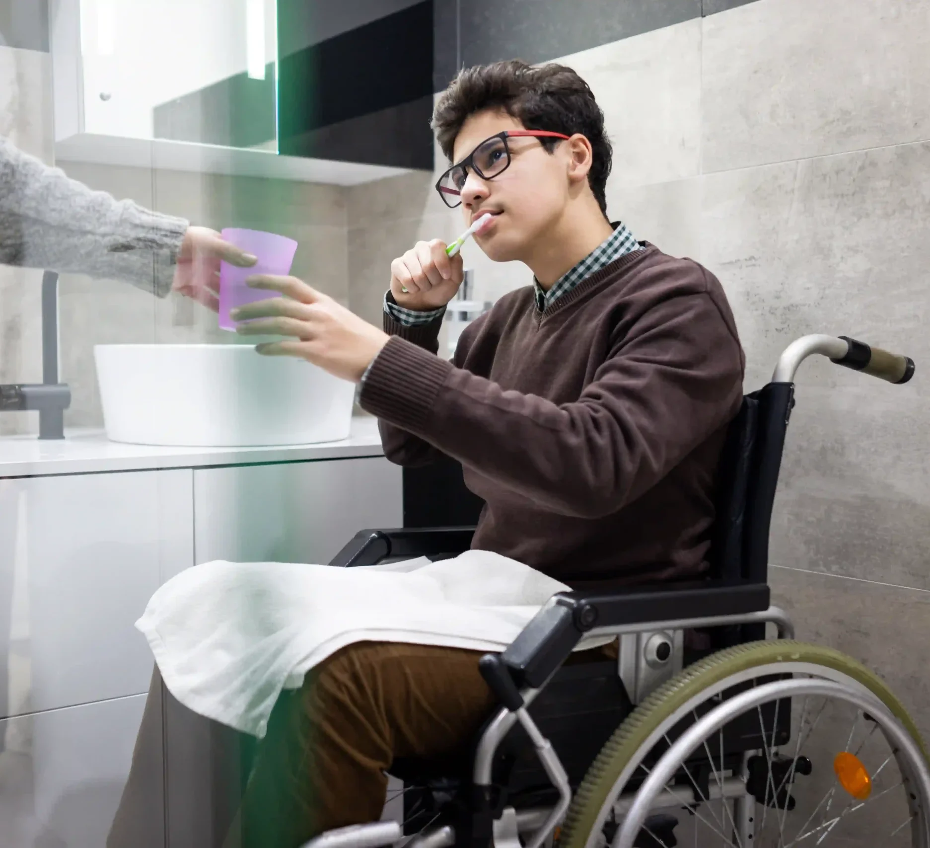 Disabled young boy on wheelchair brushing teeth