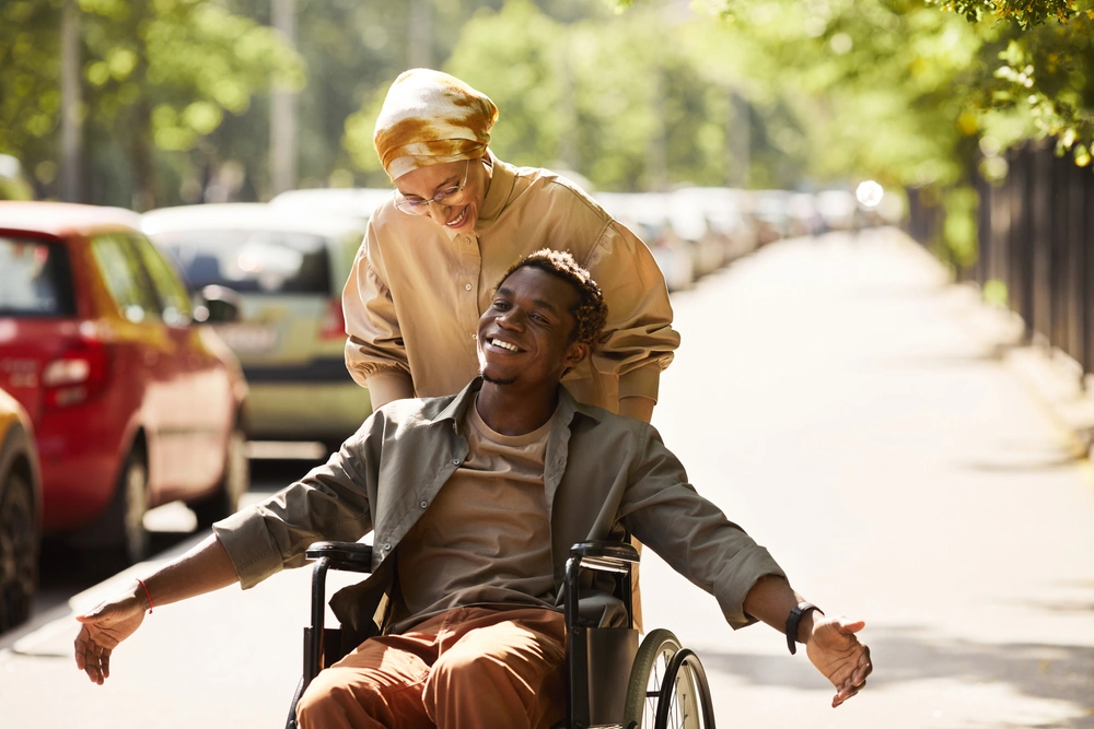 Nurse and disabled men on wheelchair walking on sidewalk