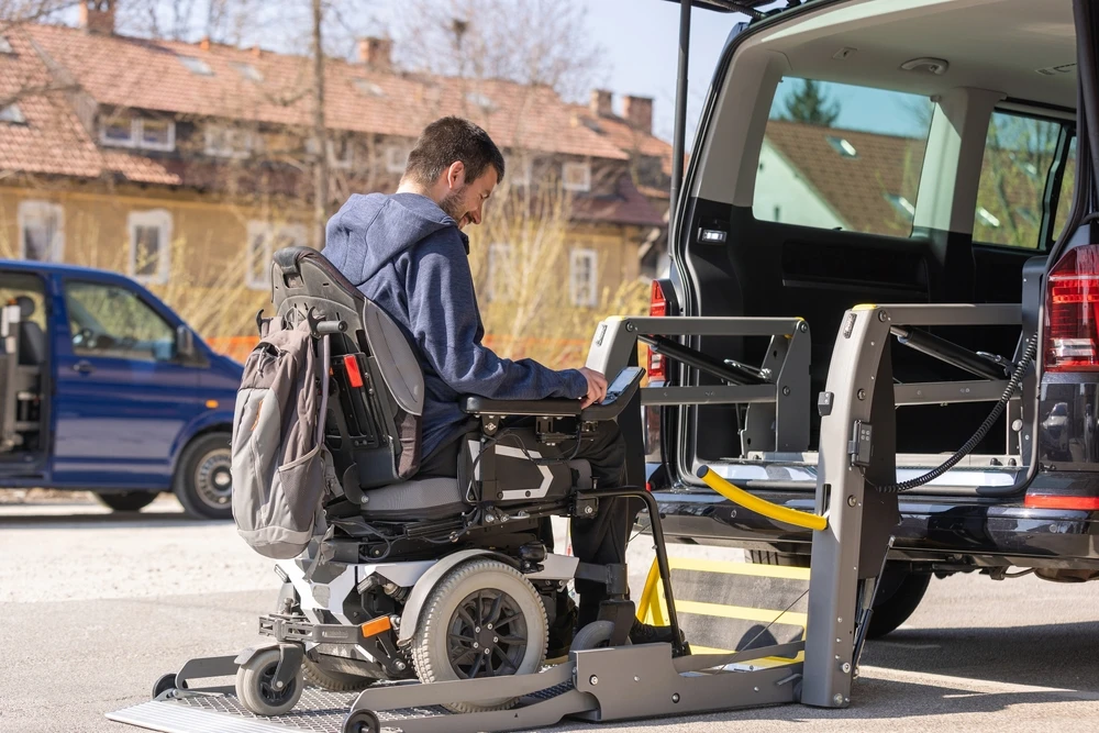 Disabled person on wheelchair getting on a van